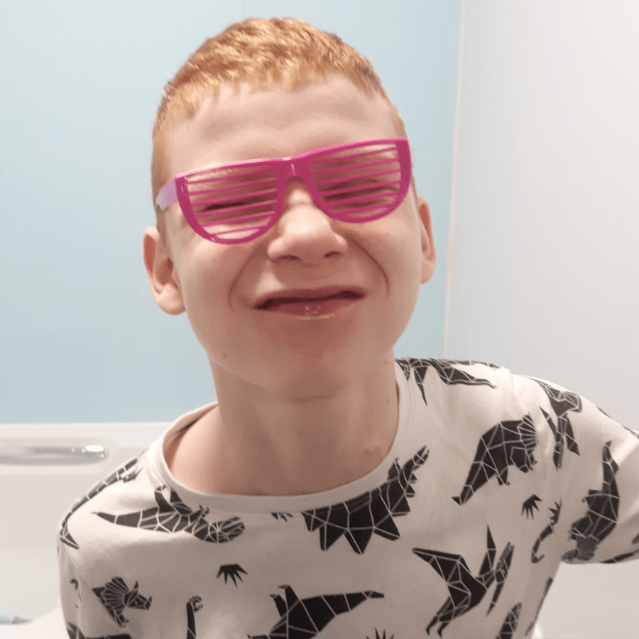 young boy wearing pink glasses
